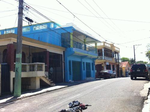 a motorcycle parked on the street in front of a blue building at Casa Azul - Apartment in San Felipe de Puerto Plata