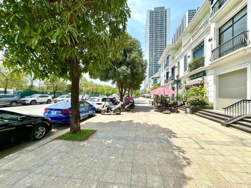 a city street with parked cars and a tree at Great Quality, Convenient To Airport Stu Apt In City Centre in Hanoi
