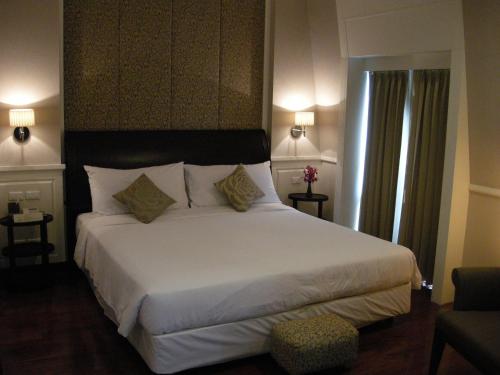 a bedroom with a large white bed with two pillows at Aurum The River Place in Bangkok