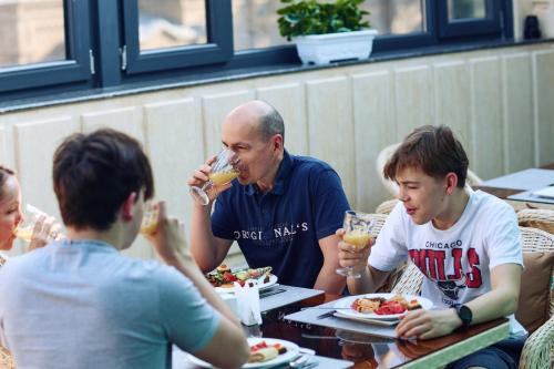 a group of people sitting at a table eating food at RIO Hotel in Samarkand