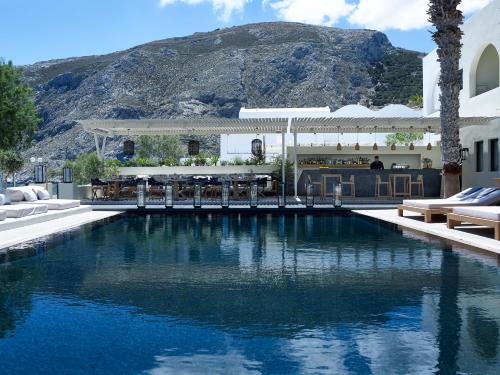 a swimming pool with a mountain in the background at Bellonias Villas in Kamari