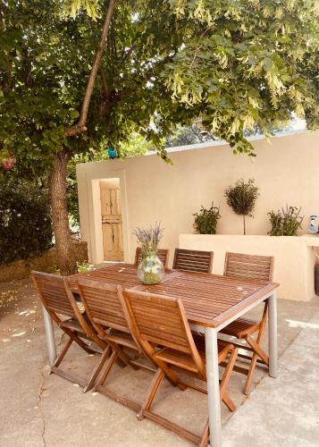une table en bois avec quatre chaises autour dans l'établissement Mas Belvega, à La Baume-de-Transit