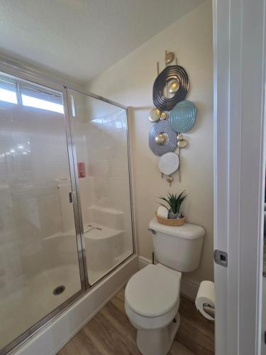 a bathroom with a toilet and a glass shower at Spacious home with golf course views and private pool in Indio