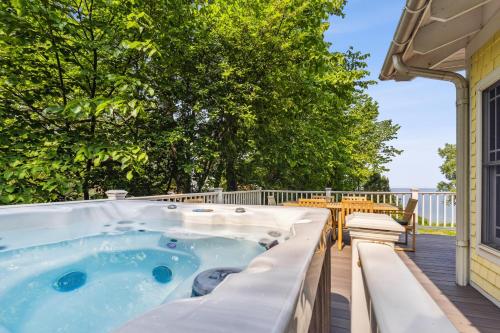 einen Whirlpool auf einer Terrasse mit einem Tisch und Stühlen in der Unterkunft Coastal Cottage in Stevensville
