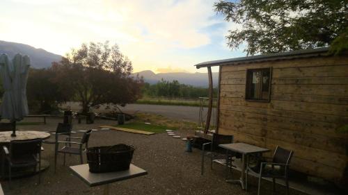 un patio avec des chaises et une table et un bâtiment dans l'établissement Hôtel Restaurant L Orée du Vercors, à Montmaur-en-Diois