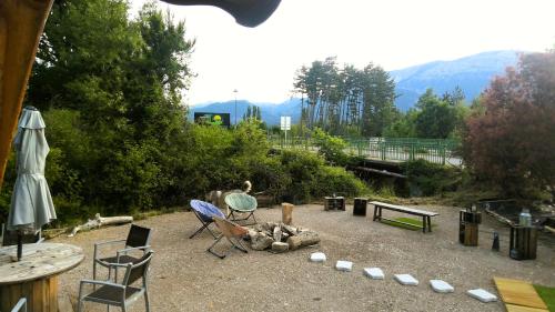 une cour arrière avec des chaises, des tables et une cheminée dans l'établissement Hôtel Restaurant L Orée du Vercors, à Montmaur-en-Diois