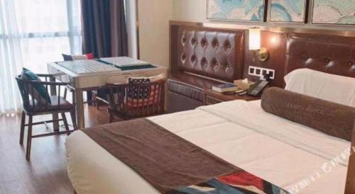 a bedroom with a bed and a desk and a table at James Joyce Coffetel Guilin Railway Station Xiangbi Mountain Liangjiang Sihu Wharf in Guilin