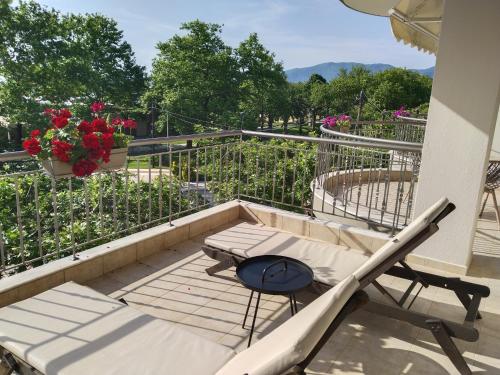 a balcony with a table and chairs and flowers at Evilion in Asprovalta