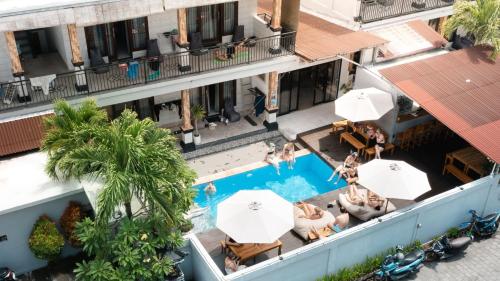 an overhead view of a hotel pool with umbrellas at Surf & Party - Hostel Somewhere Else in Canggu