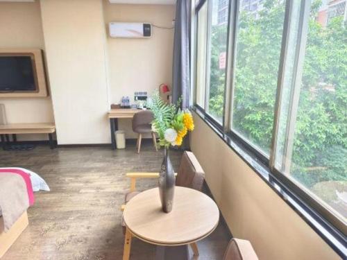 a room with a vase of flowers on a table at Thank Inn Plus Hotel Guangdong Yunfu Luoding City Municipal in Yunfu