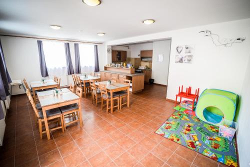 a dining room with tables and chairs and a kitchen at Dueta Apartment in Český Krumlov