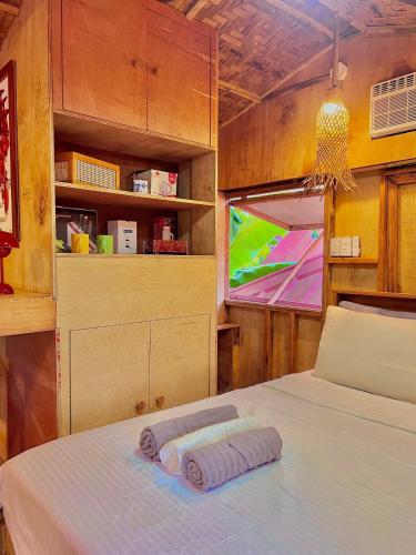 a bedroom with a bed and a tv in a room at Fully Private, Beach Access, Native Cottage, Queen Bed, AC, WiFi in General Luna