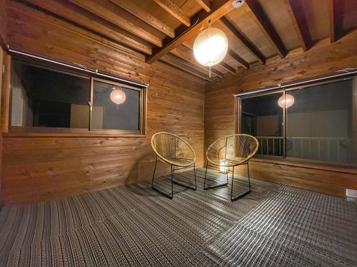 a room with two chairs and two windows at Nagomi in Ōtaki