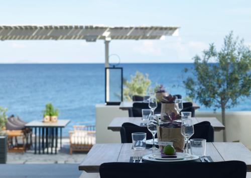 a table with wine glasses on it with a view of the ocean at Bellonias Villas in Kamari