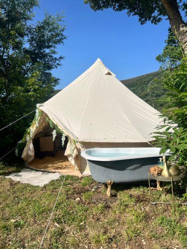 a tent with a boat in the grass at Eco- regenerative bell tent with a pool - near Piódão in Sorgaçosa