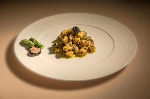 a white plate with food on a table at Villa Hotel Valle Del Marta Resort in Tarquinia