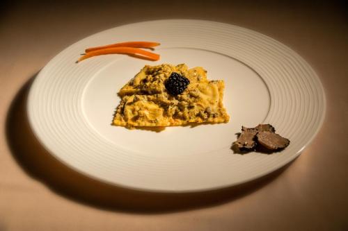 a white plate with a piece of food on it at Villa Hotel Valle Del Marta Resort in Tarquinia