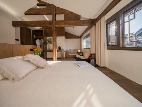 a large white bed in a room with windows at Yunshang Xiyuan in Lijiang