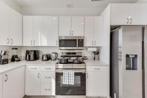 a white kitchen with a stove and a microwave at City View 2BR Apartments in Dallas