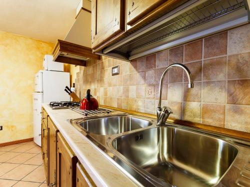 kuchnia z zlewem ze stali nierdzewnej i lodówką w obiekcie Appartamento Dal Maestro Serafino w mieście Pragelato