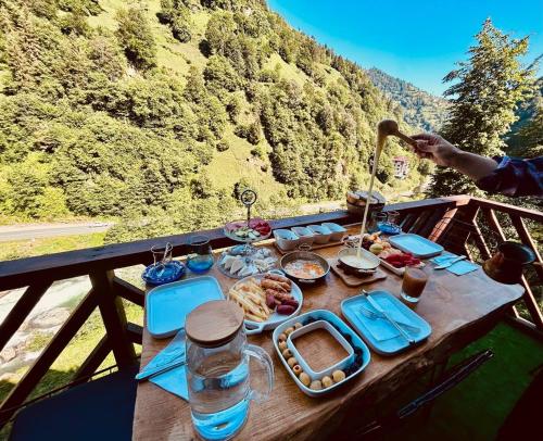 een tafel met eten erop met uitzicht op een berg bij Sisorti bungalow otel in Çamlıhemşin