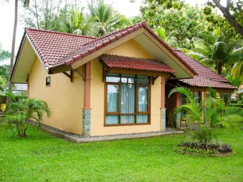 a small yellow house with a red roof at Sanghyang Indah Spa Resort in Anyer