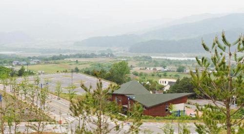 a view of a building with a mountain in the background at Mungyeong saejae Resort in Mungyeong