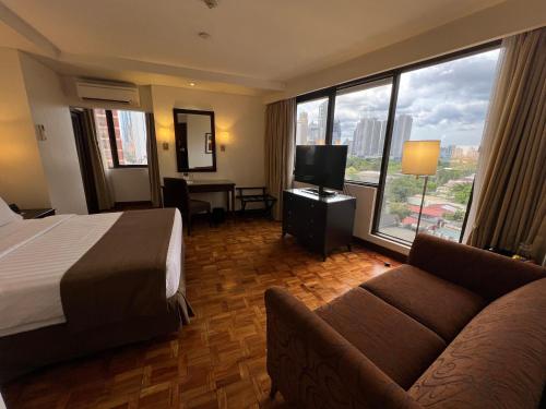 a hotel room with a bed and a couch at City Garden Hotel Makati in Manila