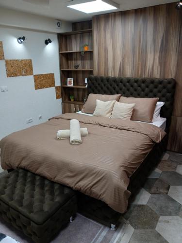 a bedroom with a large bed with a leather headboard at House therapy in Sremčica