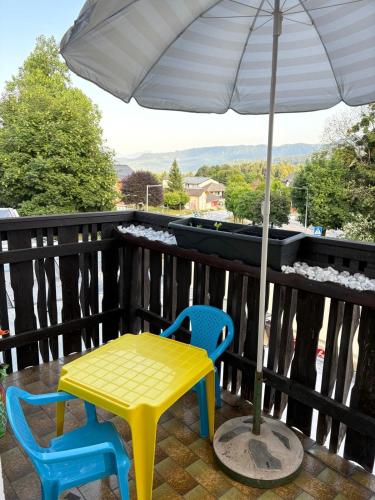 a table and two chairs and an umbrella on a balcony at Ferienwohnung Emilia in Schiefling am See