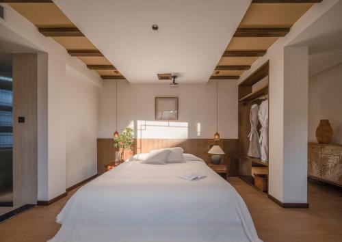 a bedroom with a large white bed in a room at Yunshang Xiyuan in Lijiang