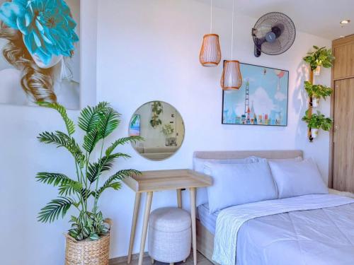 a bedroom with a bed and a table and a plant at Gạo's Homestay - The Song in Vung Tau