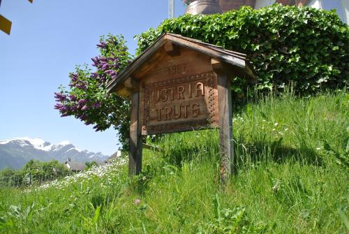 a sign in the middle of a field of grass at Ustria / Pensiun Trutg in Vella