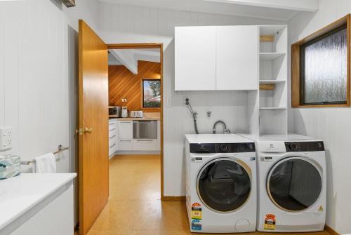 a kitchen with a washing machine in a kitchen at Relaxing Retreat on Kowhai in Wanaka