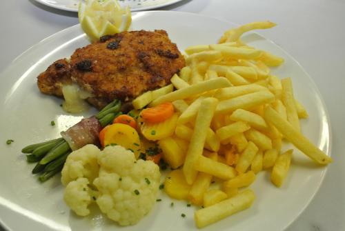 a plate of food with french fries potatoes and meat at Ustria / Pensiun Trutg in Vella