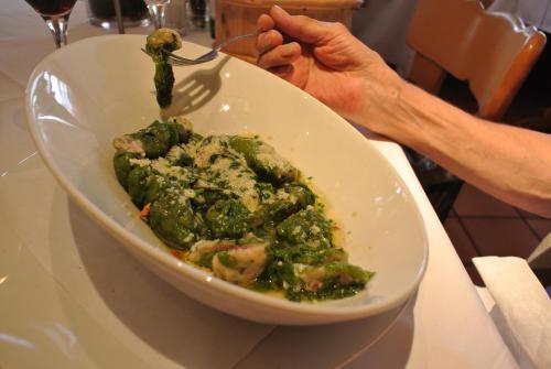 a person eating a bowl of food on a table at Ustria / Pensiun Trutg in Vella