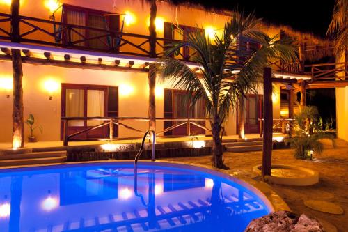 a swimming pool in front of a house at night at Casa Iguana Holbox - Beachfront Hotel in Holbox Island