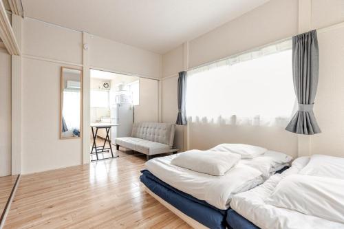 Un dormitorio con dos camas y una ventana. en tkm北小岩1丁目103, en Tokio