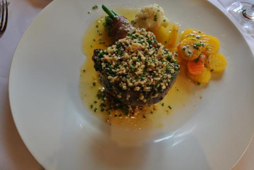 a plate of food with meat and vegetables on it at Ustria / Pensiun Trutg in Vella