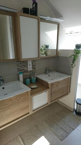 une salle de bain avec deux lavabos et deux miroirs dans l'établissement Beautiful house with sea view, à Lamballe Armor