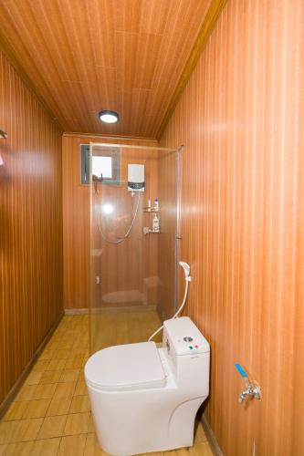 a bathroom with a toilet and a glass shower at Vân Hòa Phú Yên homestay highland in Tuy Hoa