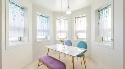 a dining room with a table and chairs and windows at Gallery Pension in Taean