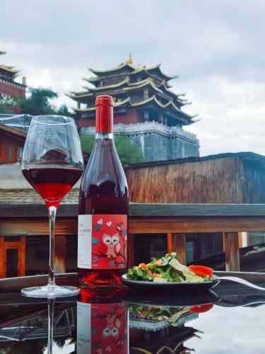 a glass of wine sitting next to a plate of food at Arro Khampa By Zinc Journey Shangri-la in Shangri-La