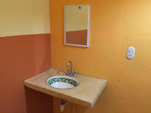 a bathroom sink with a mirror on a wall at Hotel Las Salinas in Zihuatanejo