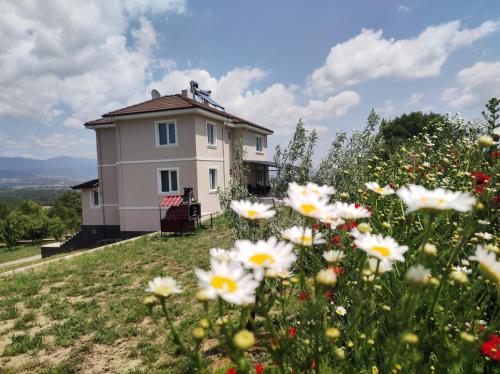 a house on a hill with flowers in the foreground at Akkayalar Aerie House in Çepni