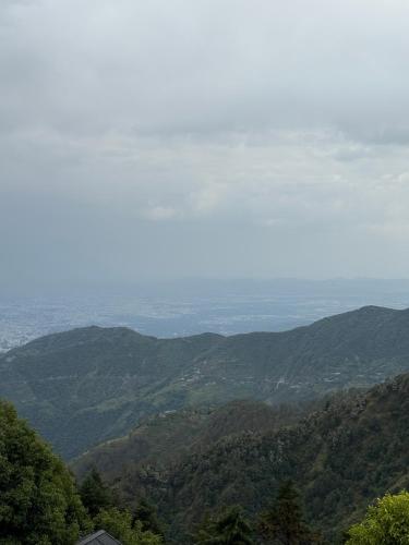 a view of a valley with mountains in the distance at Nuri By The Hills Mountain Retreat with Jacuzzi in Mussoorie