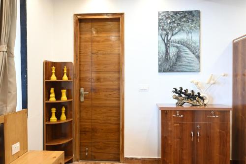a room with a wooden door and a wooden cabinet at Nuri By The Hills Mountain Retreat with Jacuzzi in Mussoorie