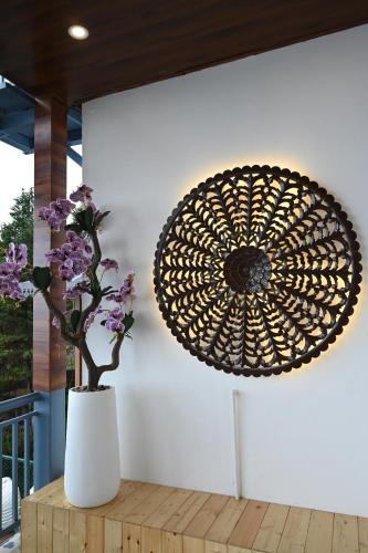 a vase with purple flowers in a white vasestrationstration at Nuri By The Hills Mountain Retreat with Jacuzzi in Mussoorie