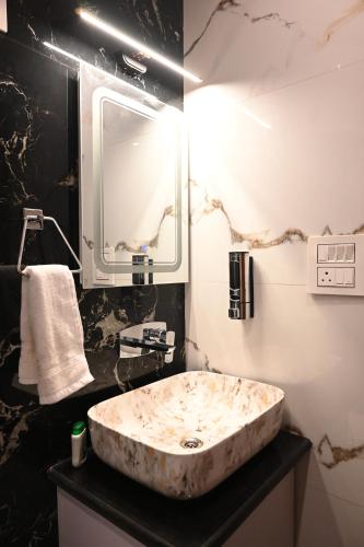 a bathroom with a marble sink and a mirror at Nuri By The Hills Mountain Retreat with Jacuzzi in Mussoorie