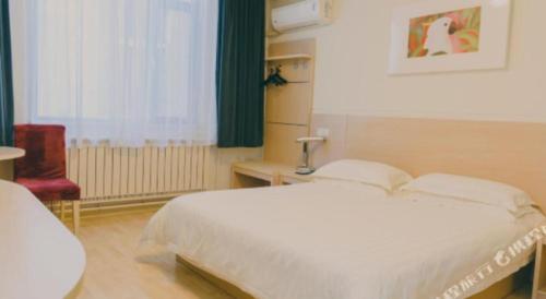 a bedroom with a large white bed and a chair at Jinjiang Inn Qingdao Development Zone Jinggangshan Rd. in Huangdao